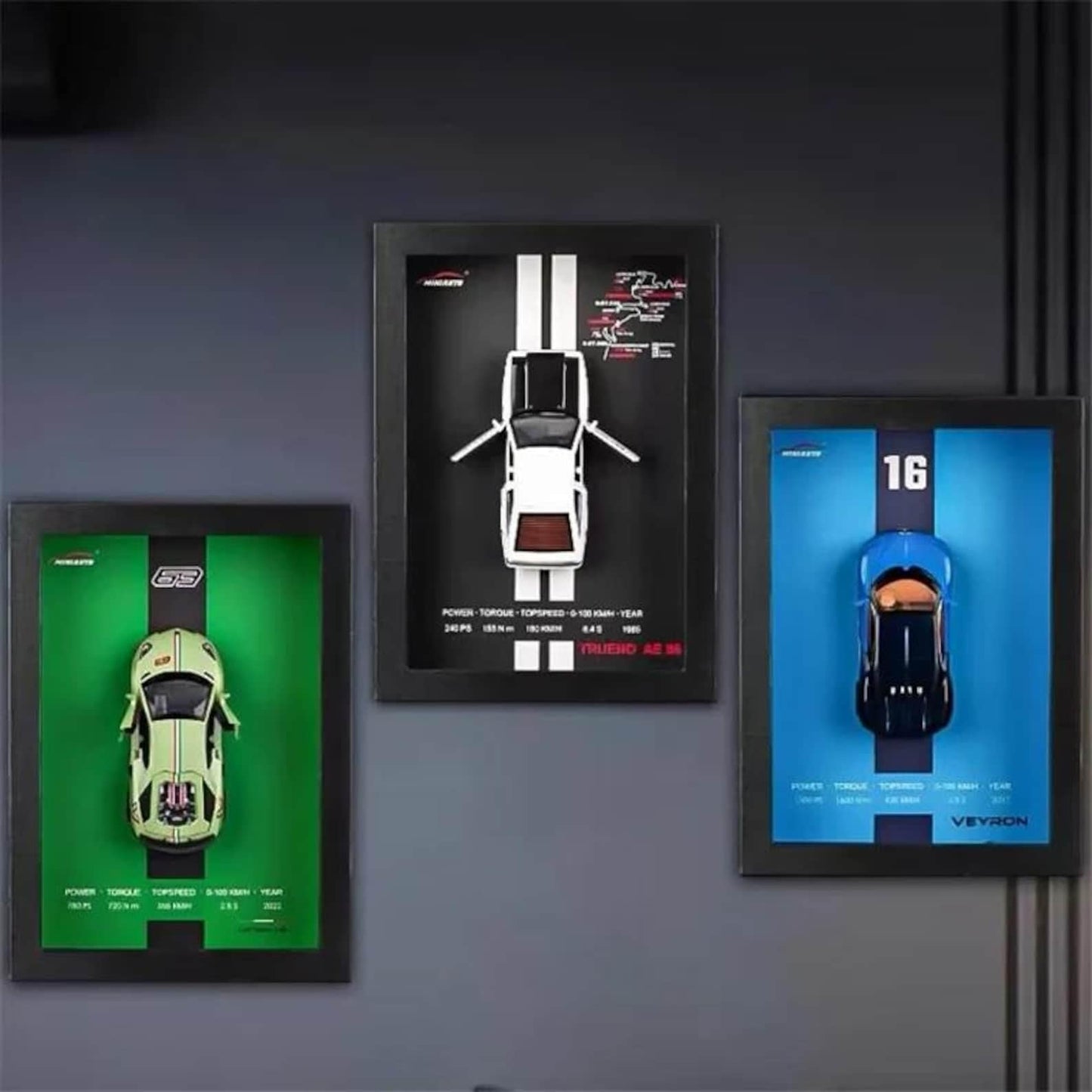 Three framed car models on a dark wall
