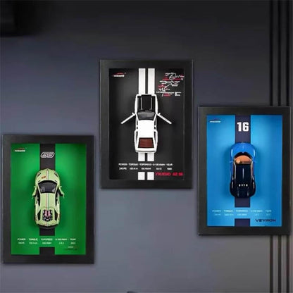 Three framed car models on a dark wall