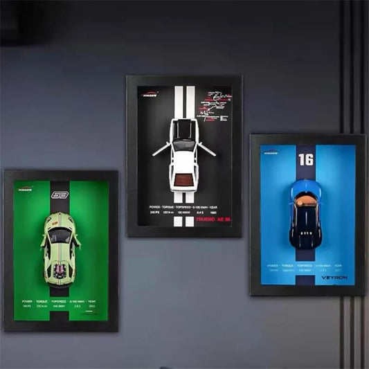 Three framed car models on a dark wall
