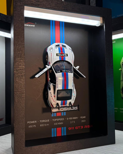 Close-up of Toy Rush 3D car frame with realistic die-cast cars and glowing LED lights in a wooden display case.