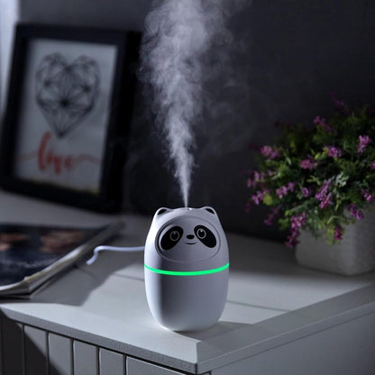 Panda-shaped humidifier emitting mist on a nightstand with a plant and framed picture in the background.