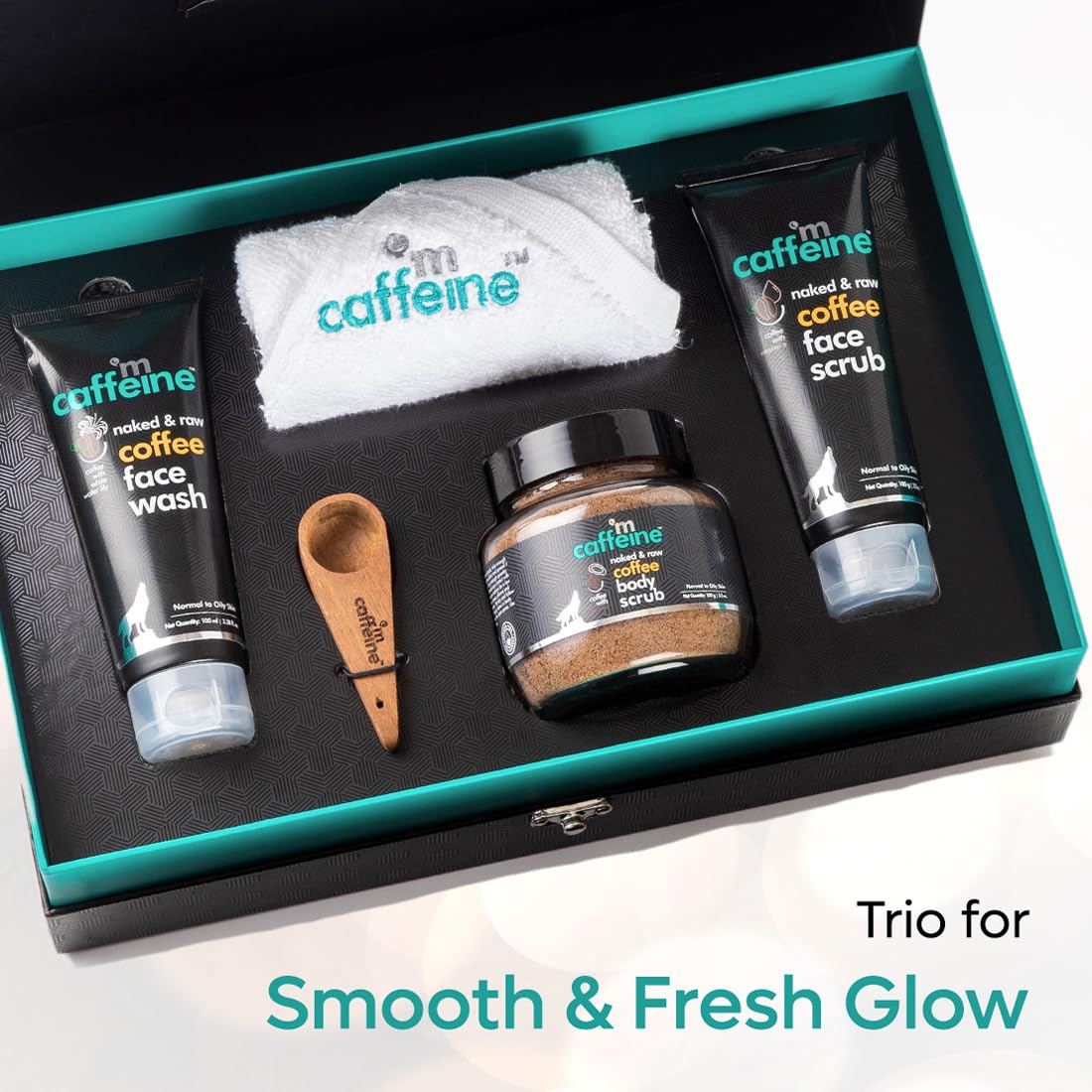 Caffeine skincare product set with face wash, scrub, body scrub, and towel in a box.